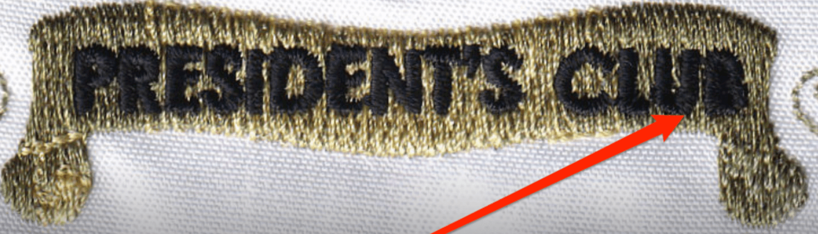 Small embroidered 'President's Club' text with the letters closed up β the bowls filled with thread and the word reading as a smudge